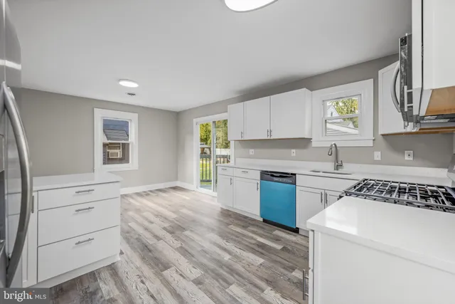 a kitchen with granite countertop white cabinets and white appliances