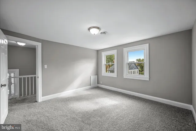 an empty room with windows and closet