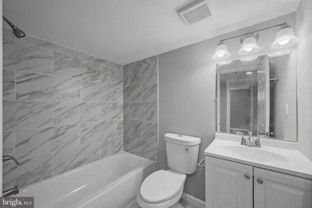 a bathroom with a toilet a sink a mirror a bathtub and shower