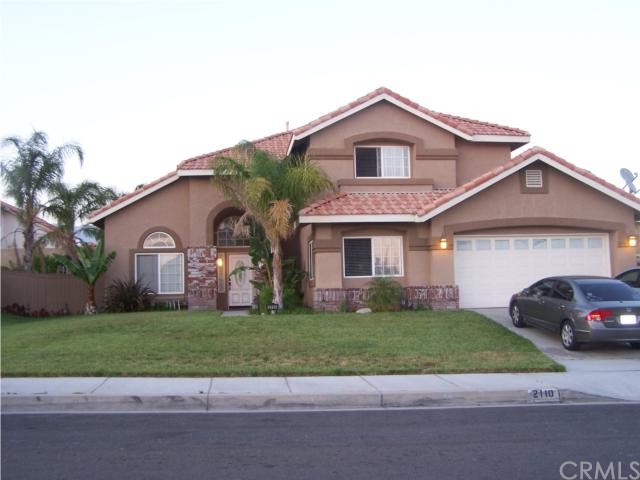 2110 West Autumn Mist Drive Rialto, CA 92377 - Photo 1 of 1 a car parked in front of a house with a yard