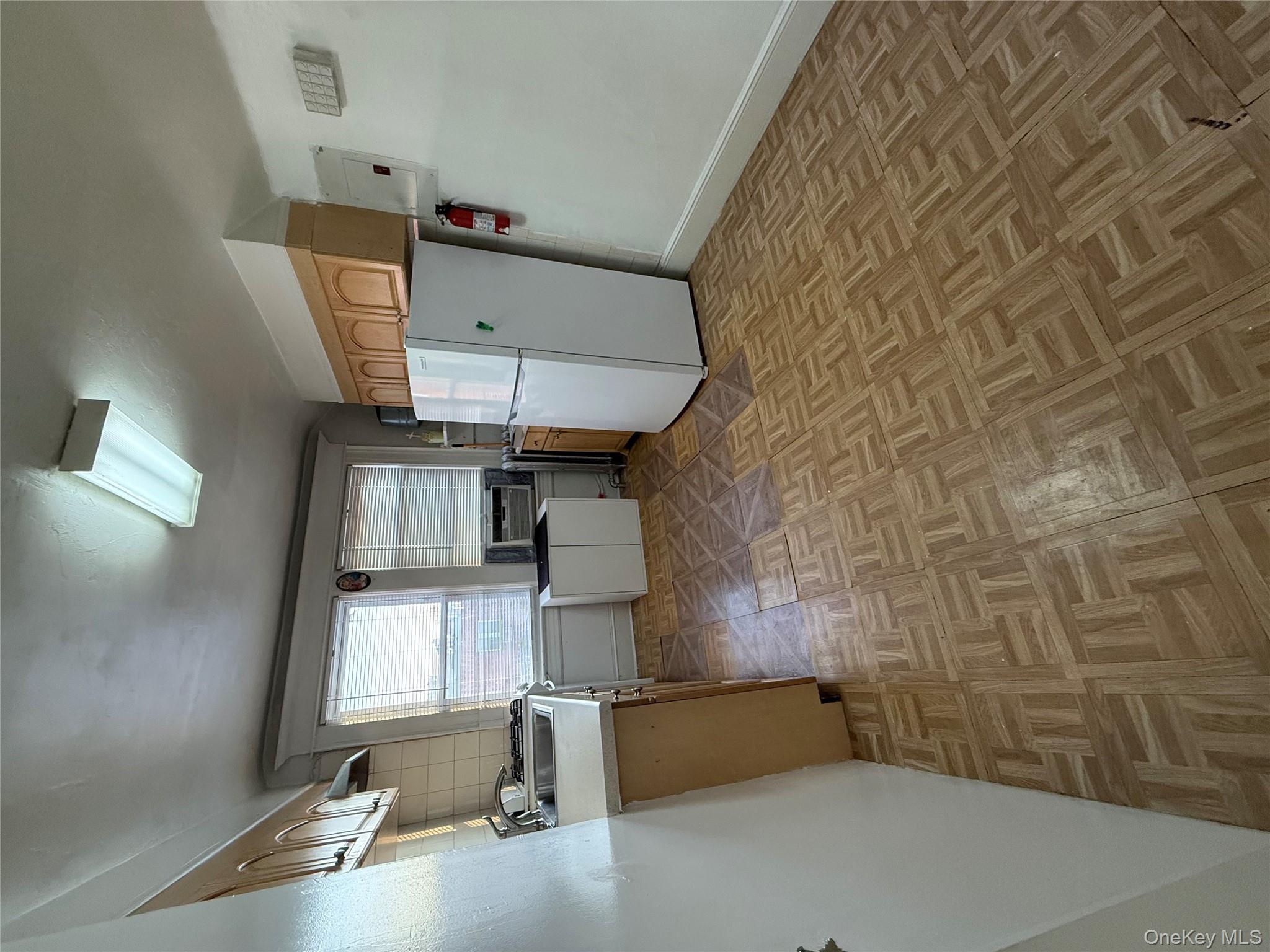 92-40 53rd Avenue, Unit 3 Queens, NY 11373 - Photo 7 of 8 a view of kitchen with utility cabinets and window