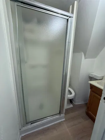 a bathroom with a granite countertop shower and a toilet