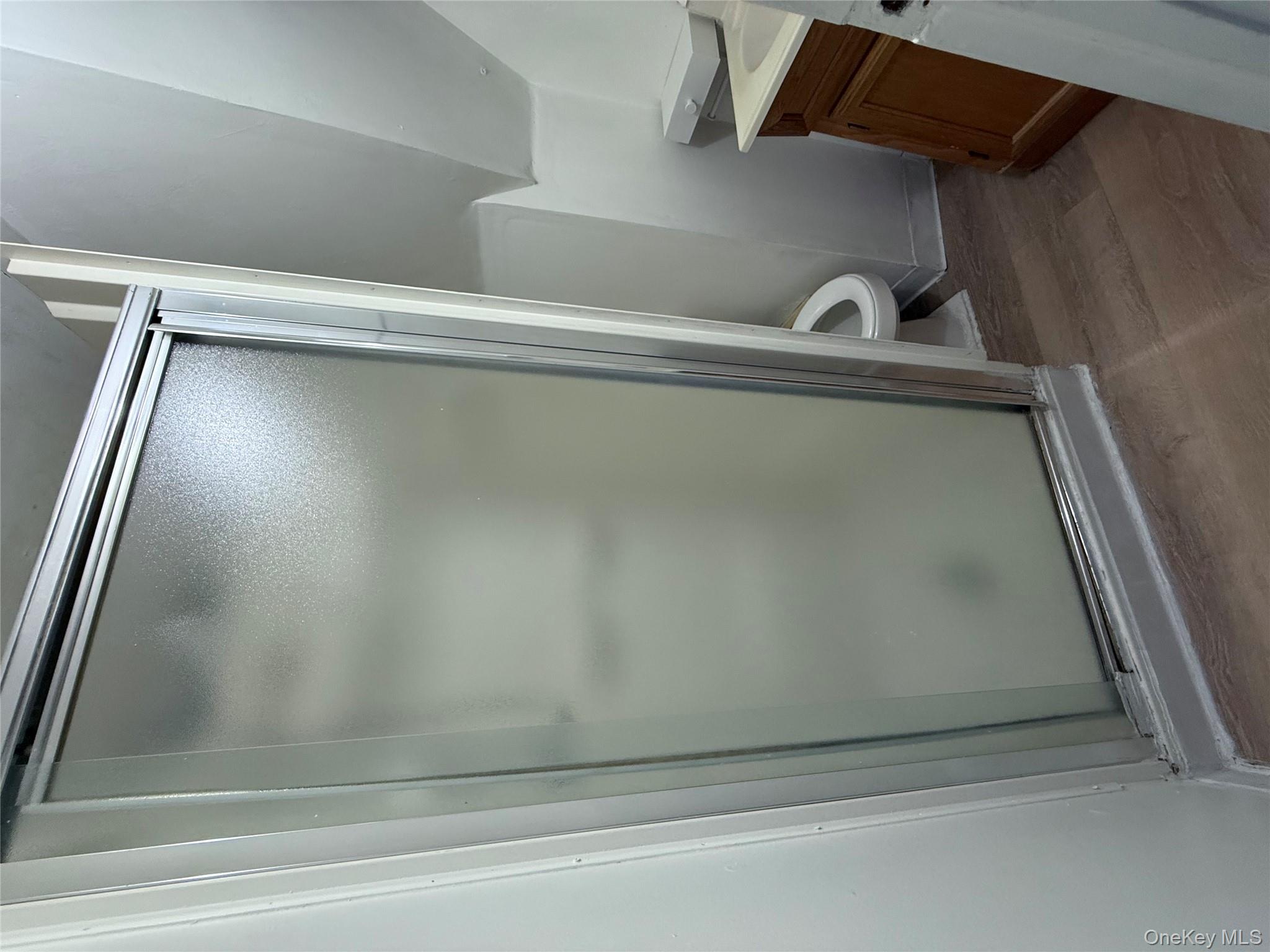 92-40 53rd Avenue, Unit 3 Queens, NY 11373 - Photo 8 of 8 a bathroom with a granite countertop shower and a toilet