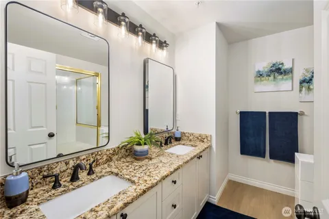 a bathroom with a granite countertop sink and a mirror