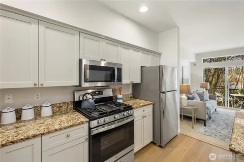 a kitchen with stainless steel appliances granite countertop a refrigerator stove and sink