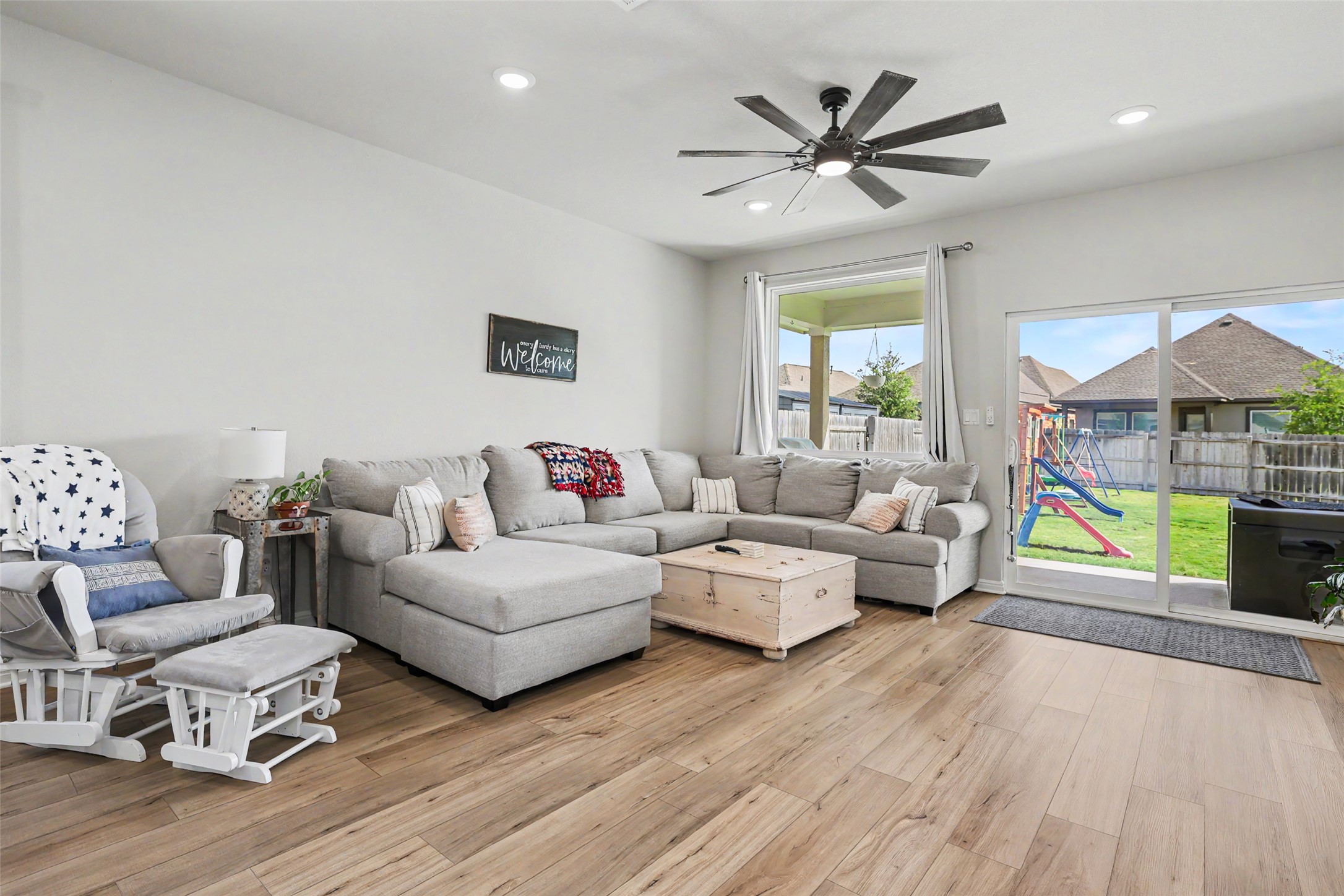 112 Rocking R Court Georgetown, TX 78633 - Photo 12 of 40 Wood flooring seamlessly connects the inviting living space to the fenced backyard through sliding glass doors.