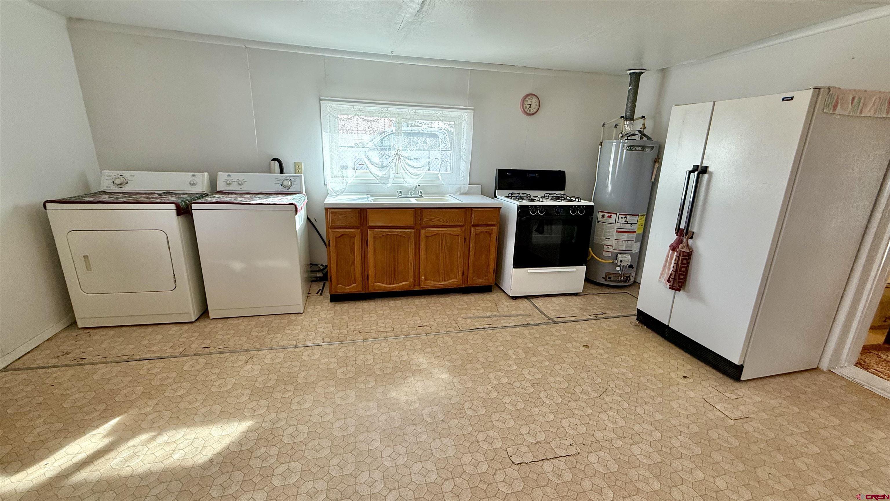 1704 Ross Avenue Alamosa, CO 81101 - Photo 21 of 28 a utility room with refrigerator a washer and dryer