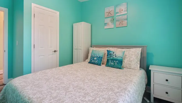 a bedroom with a bed and a painting on the wall