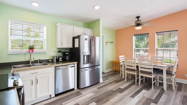 a kitchen with white cabinets and wooden floor