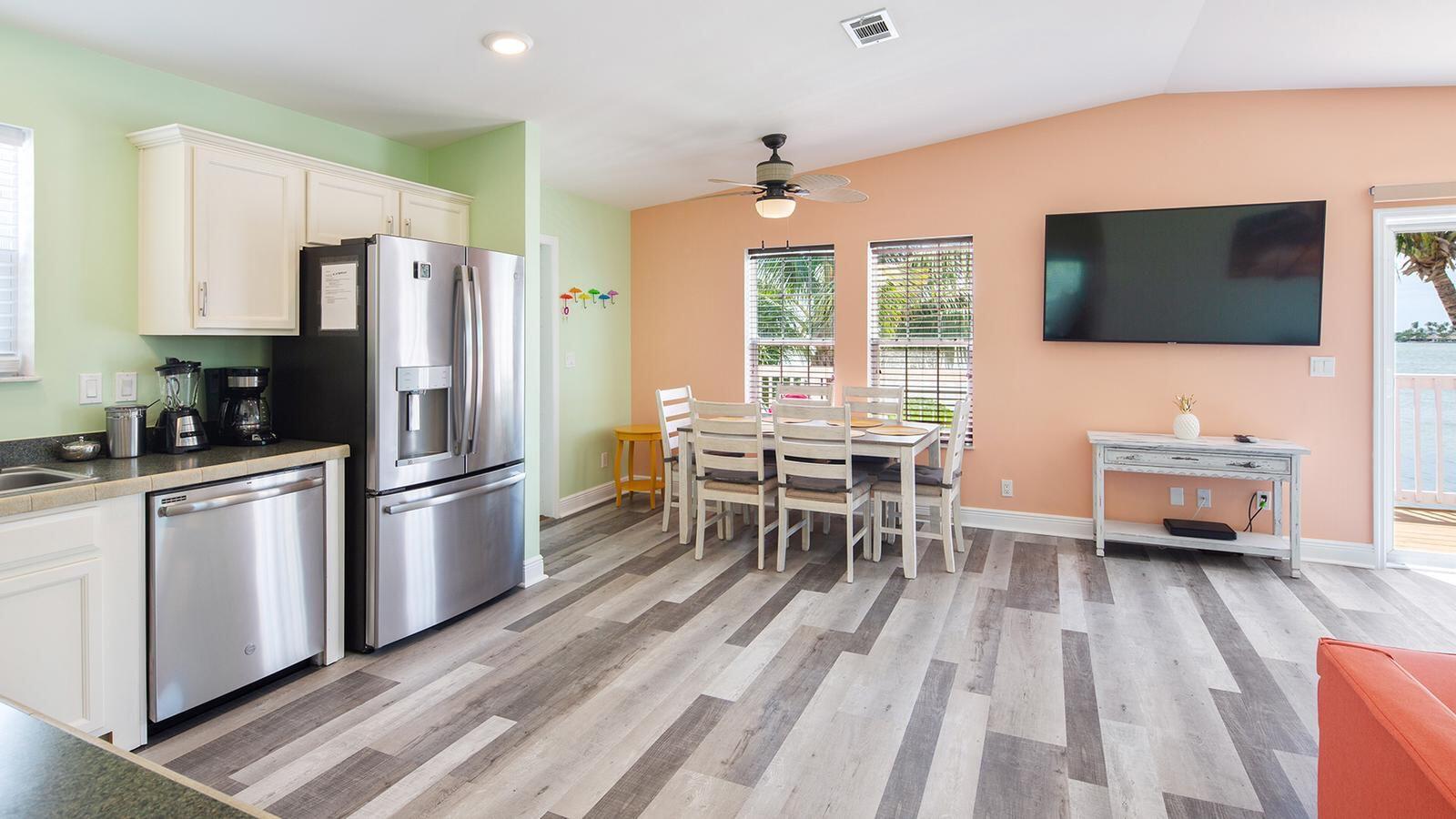 32 Beach Drive Key West, FL 33040 - Photo 8 of 33 a kitchen with stainless steel appliances a refrigerator a stove a dining table and chairs with wooden floor
