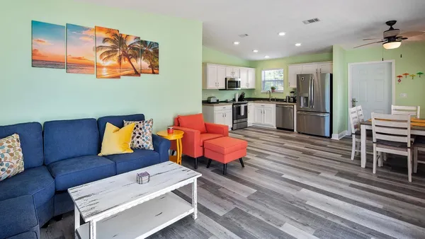 a living room with furniture and kitchen view