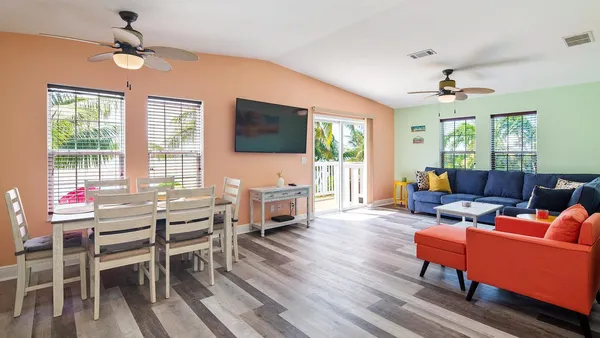 a living room with furniture a flat screen tv and a large window