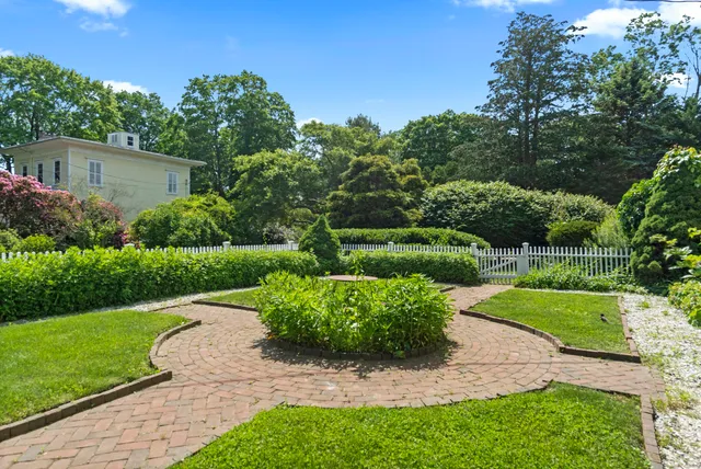 a view of a garden with a house in the background