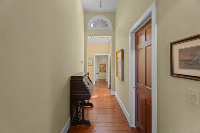 a view of a hallway with wooden floor and a living room
