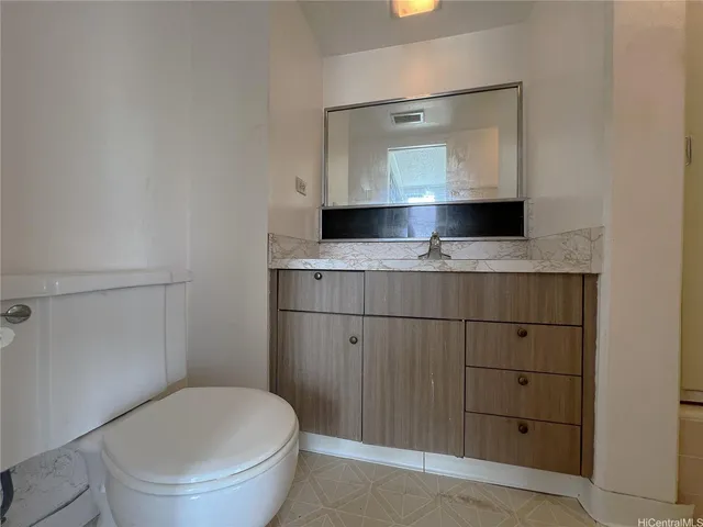 a bathroom with a toilet a sink and mirror