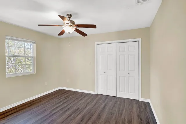 a view of empty room with wooden floor