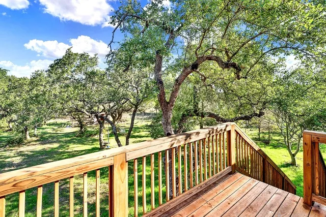 a view of deck and a yard with wooden fence