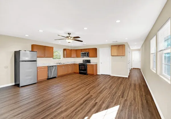 a view of a kitchen with wooden floor and electronic appliances