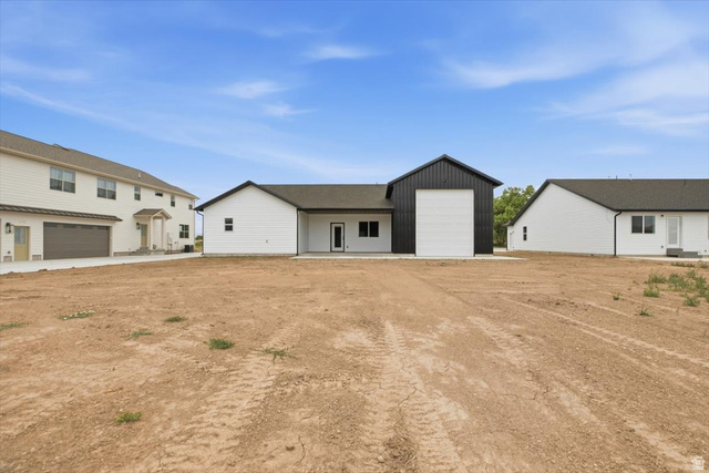 164 North 400 East Preston, ID 83263 - Photo 18 of 21 Expansive backyard space with a barn-style detached garage featuring a large white overhead door