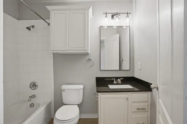 a bathroom with a granite countertop sink a toilet and shower