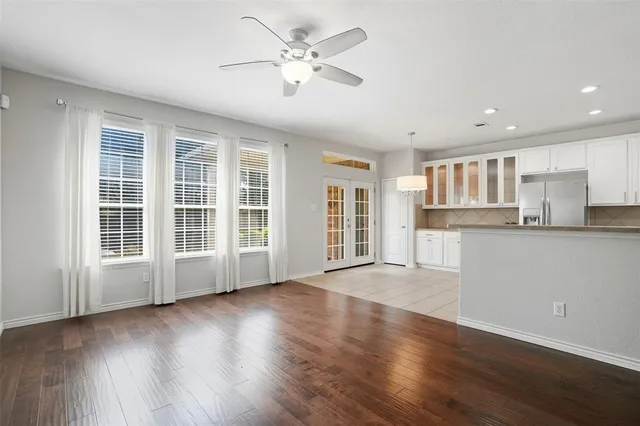 a view of an empty room with a kitchen and wooden floor