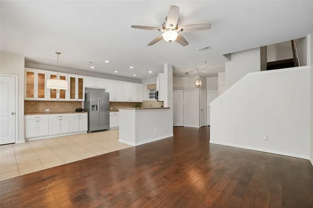 a view of kitchen with refrigerator stove and wooden floor