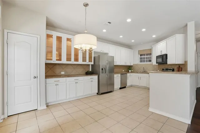 a open kitchen with granite countertop white cabinets white stainless steel appliances with a sink and dishwasher