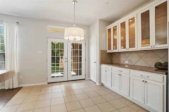 a view of an empty room with cabinet and windows