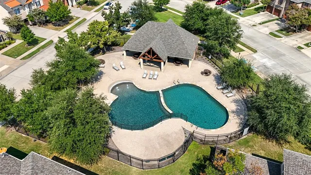 an aerial view of a house with swimming pool and outdoor seating