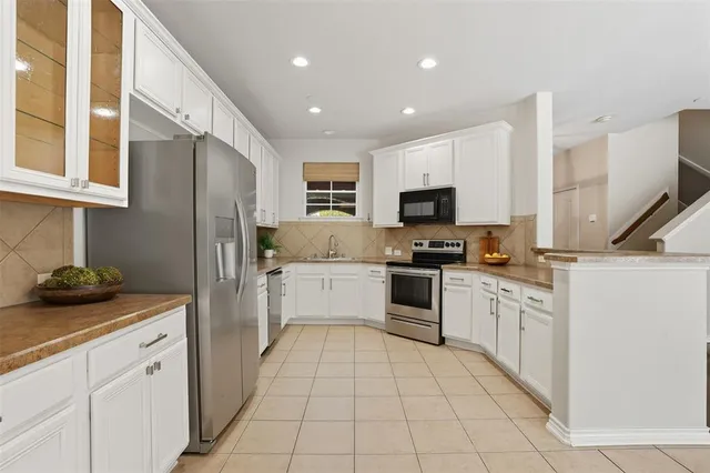 a kitchen with white cabinets and stainless steel appliances