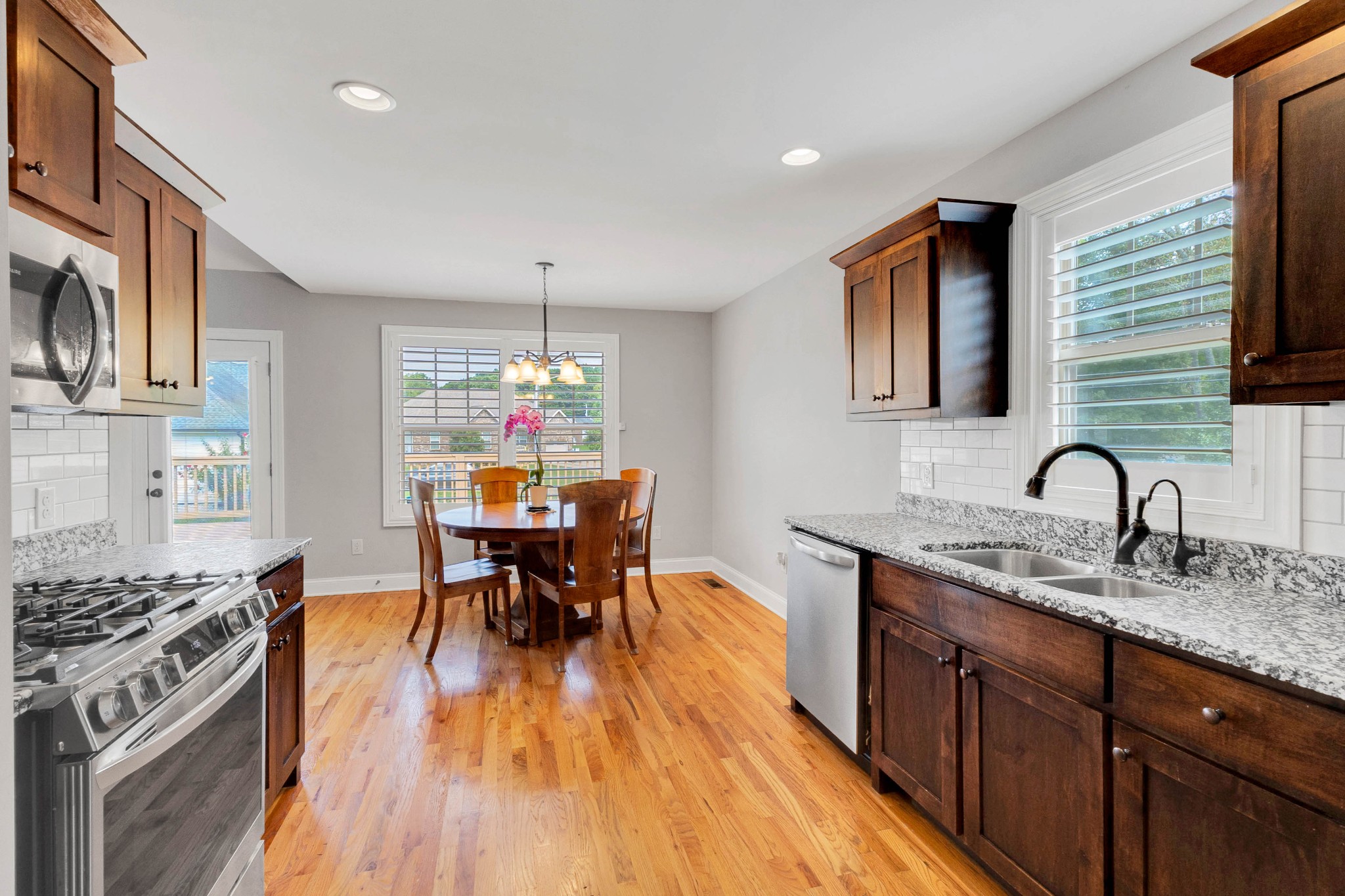 509 Gunn Lane Springfield, TN 37172 - Photo 19 of 48 a kitchen with stainless steel appliances granite countertop a stove top oven a sink dishwasher a dining table and chairs with wooden floor