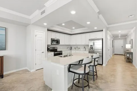 a kitchen with stainless steel appliances kitchen island granite countertop a stove a sink a dining table and chairs with wooden floor