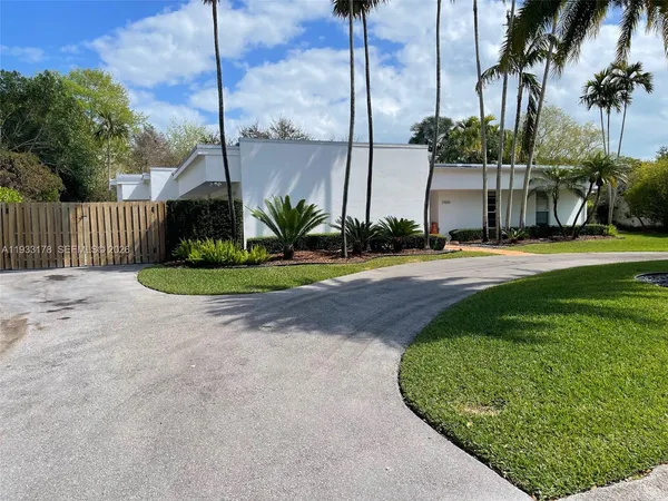 a front view of a house with a garden and plants