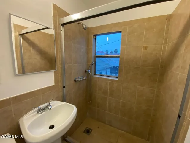 a bathroom with a sink a mirror and a shower