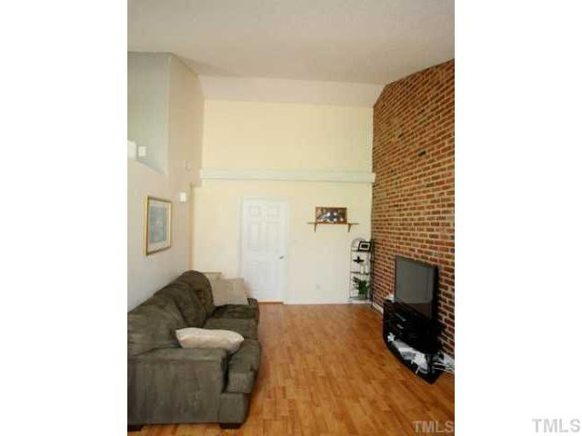 5418 Wayne Street Raleigh, NC 27606 - Photo 2 of 11 High Ceiling, Gorgeous Exposed Brick Wall, NEW Laminate Flooring, Fresh Interior Paint, Easy Bedroom Access. Living Room