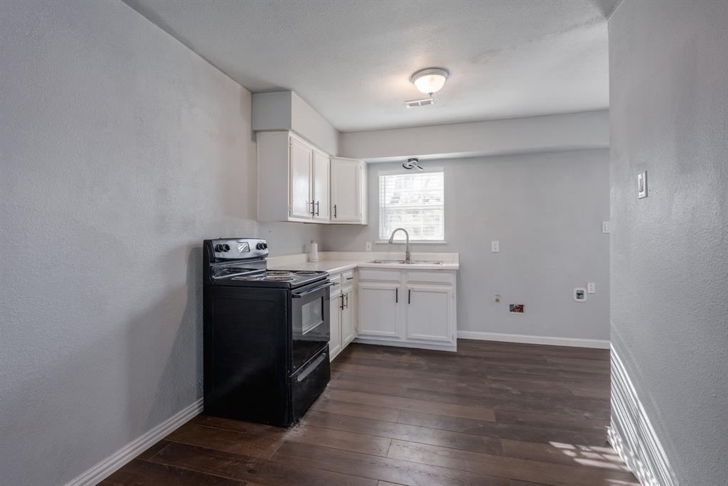 2824 Lockhart Avenue Dallas, TX 75228 - Photo 6 of 16 a kitchen with sink a microwave and cabinets