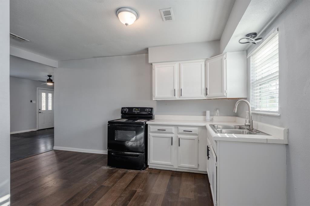 2824 Lockhart Avenue Dallas, TX 75228 - Photo 8 of 16 a kitchen with a sink a window and cabinets