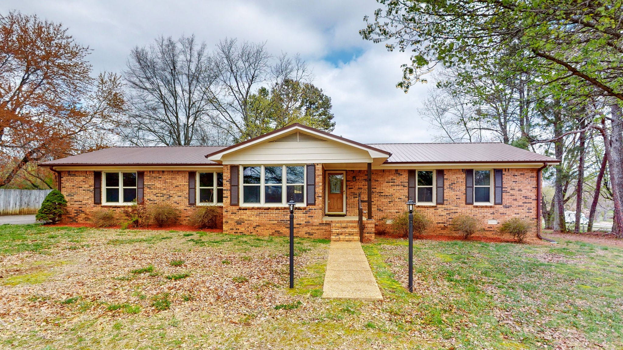 a front view of a house with a yard porch and tree