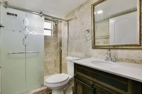 a bathroom with a sink a toilet and shower