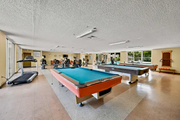 a living room with furniture pool table and a flat screen tv