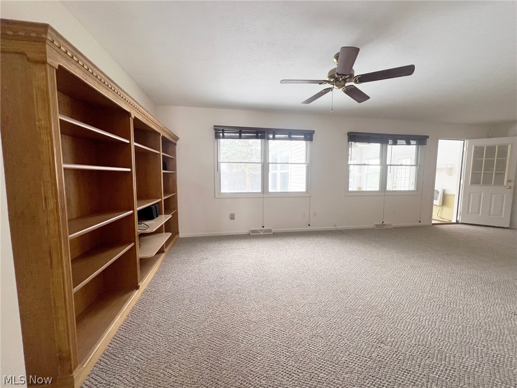 5203 Ridgeland Street Lorain, OH 44055 - Photo 14 of 39 Carpeted spare room featuring a wall unit AC, a healthy amount of sunlight, and ceiling fan