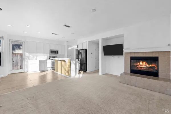 a view of a kitchen with refrigerator and white cabinets