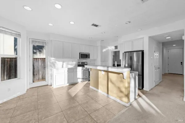 a view of a kitchen with refrigerator and window