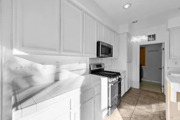 a kitchen with granite countertop white cabinets and stainless steel appliances