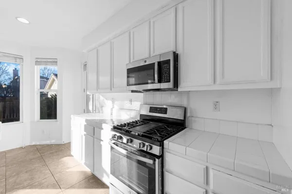 a kitchen with a stove sink and cabinets