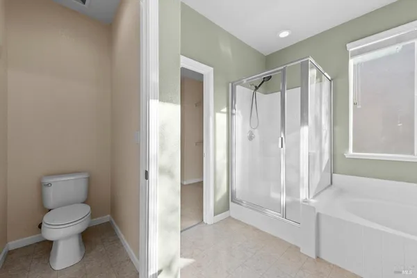 a spacious en suite bathroom with a granite countertop sink a mirror and a