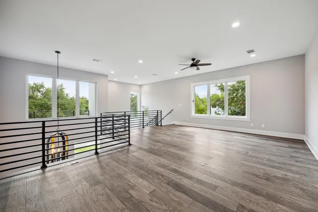 a kitchen with stainless steel appliances granite countertop a stove a sink dishwasher a refrigerator white cabinets with wooden floor