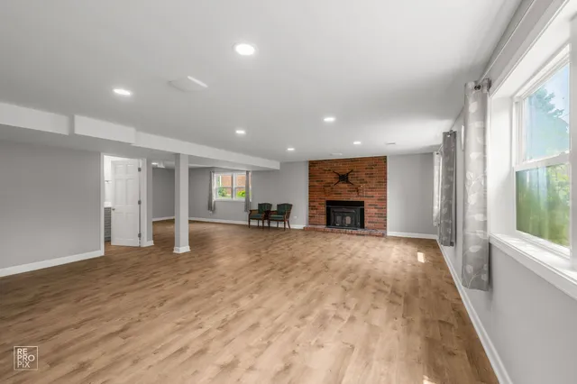 a view of an empty room with a fireplace and a window