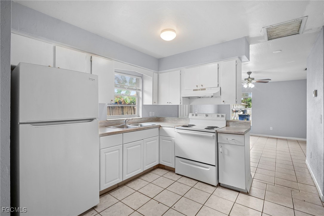 5449 Tenth Avenue Fort Myers, FL 33907 - Photo 7 of 18 a kitchen with white cabinets and white appliances