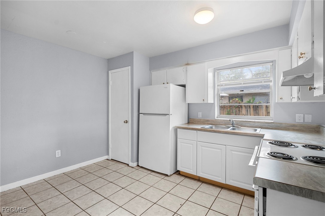 5449 Tenth Avenue Fort Myers, FL 33907 - Photo 8 of 18 a kitchen with white cabinets and white appliances